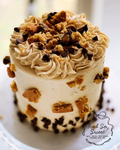 Small cake with cookie crumbles and chocolate chips on a white plate, branded 'Iced So Sweet'.