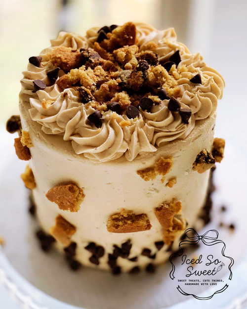 Small cake with cookie crumbles and chocolate chips on a white plate, branded 'Iced So Sweet'.